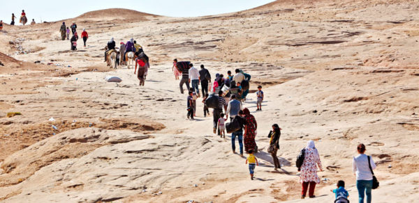 Grupo de personas huyendo por el desierto