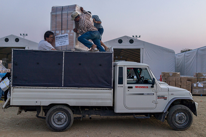 Voluntarios de ACNUR cargan ayuda humanitaria para los afectados por el terremoto en Nepal