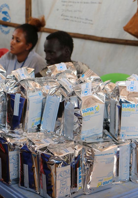 Raciones de comida para niños con el Programa Mundial de Alimentos Reparto de comida junto al PMA