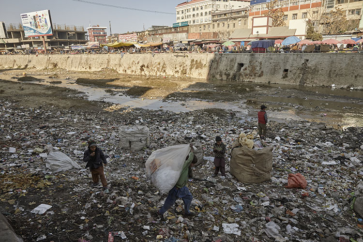 Niños afganos recogiendo plástico