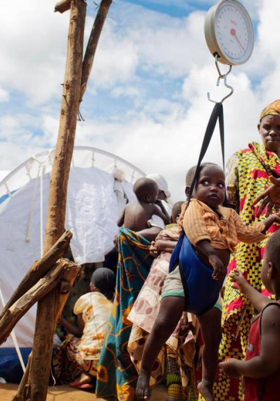 Burundeses en Ruanda pesando a un niño